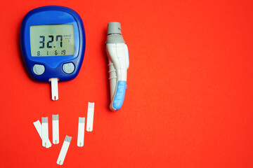 A blood glucose meter with a high blood sugar reading lies on a wooden table. Blood sugar...