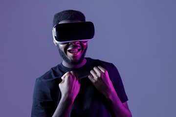 Obraz premium African American guy in Smart glasses of virtual reality. Augmented reality game, future technology, AI concept. VR. Neon light.