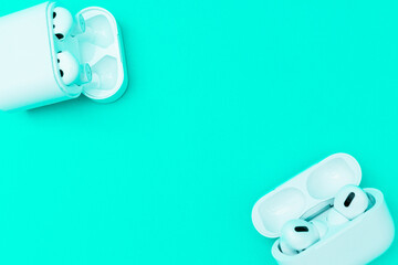 White wireless headphones on neon green background