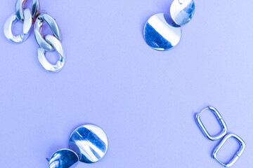 Earrings lying on a blue background, blue shade of photo