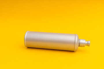 Grey shampoo bottle on a yellow background
