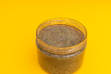 Body and head scrub in a jar on a yellow background
