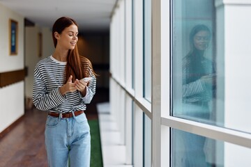 Fototapeta premium Woman with phone in hand online shopping from home, the concept of technology and saving time via smartphone internet, the copy space