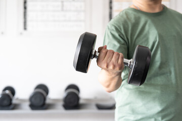 man workout in the indoor gym, man lifting up a Hammer Curl weight exercise. bodybuilding dumbbells in gym. training in fitness gym.
