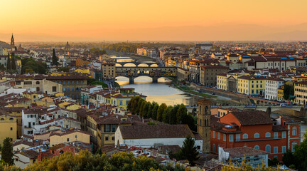 Fototapeta na wymiar The Florence cityscape with the Ponte Vecchio over Arno river in an orange sunset.