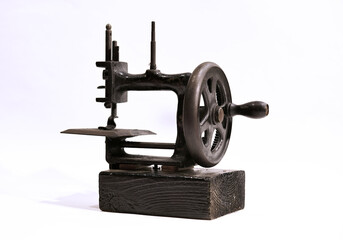 An antique hand crank sewing machine with white background