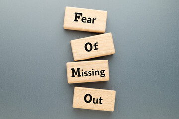 Fear of Missing Out text on wooden blocks, FOMO mental health, FOMO marketing, topic