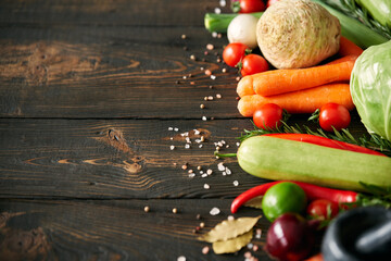 Assorted raw organic vegetables on dark wooden background with copy space