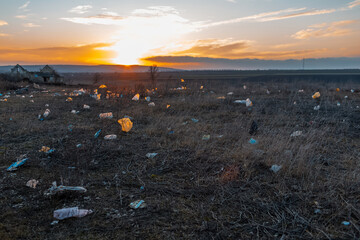 Urban garbage in polluted field at sunset. Environmental concept.