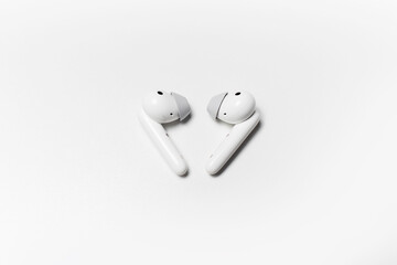 Close-up of modern wireless earphones isolated on white studio background.