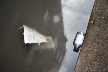 Disgusting litter floating in a dirty city puddle