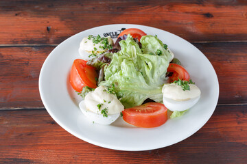 Salade tomate mozzarella sur une table en bois