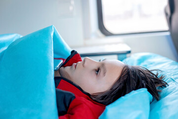 Preteen child, boy, lying in ambulace, being transported to the hospital with fractured thoracic spine, vertebralis © Tomsickova