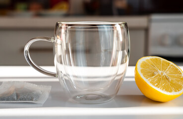 Tea drinking concept. Empty cup, tea bag and lemon slice on the table. Close-up. Selective focus.