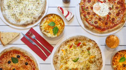 Composition des plats italiens servie sur fond rustique foncé, vue de dessus. Assortiment de pizza. Soirée pizza.