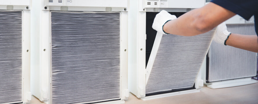 Air purifier technician open cover to fix and holding dirty and dusty air filter for removing and change. Concept of heat and clean or maintenance air conditioner service repair and install.