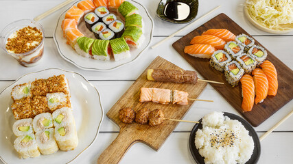 Composition des plats japonais, servie sur fond rustique foncé, vue de dessus. Ensemble de cuisine japonaise. Assortiment de sushi. Buffet à volonté - obrazy, fototapety, plakaty
