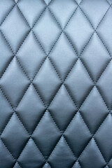 Quilted black leatherette surface close-up photography.