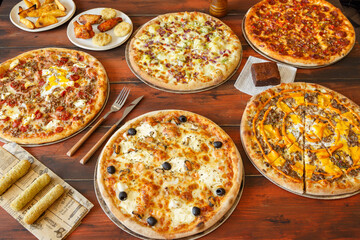 Fototapeta na wymiar Composition des plats italiens servie sur fond rustique foncé, vue de dessus. Assortiment de pizza. Soirée pizza.