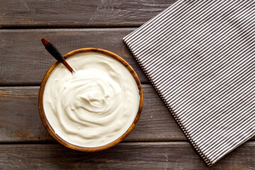 White sauce sour cream or yogurt in wooden bowl, top view