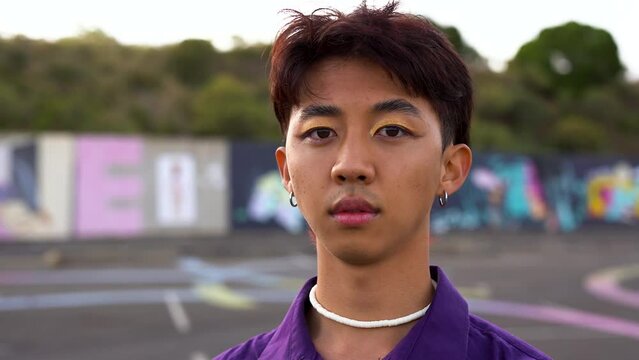 Young asian gay man with make up looking on camera
