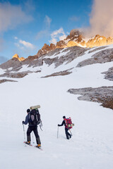 Snow hiker walking in a snowy hillside in a sunny day