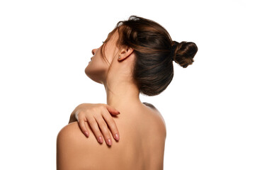 Side view image. Healthy back, massage. One beautiful brunette girl posing against white studio background. Concept of natural beauty, youth, health, wellness, health, femininity, make-up