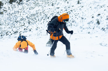 Snow hikers climbing a snowy mountain during a snowstorm