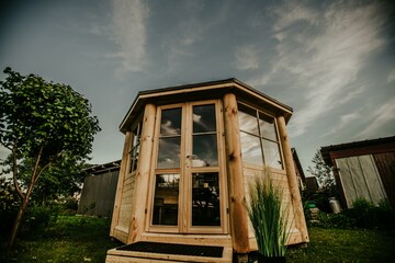 Wooden conceptual project of tiny house with transparent glass walls