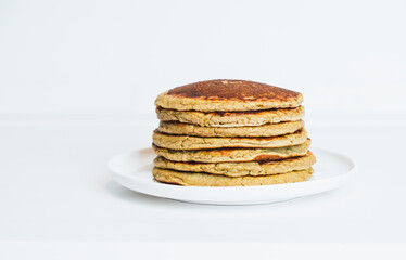 Freshly cooked soft delicious gluten free pancakes stacked on white plate. Space for text. Healthy sweet food.