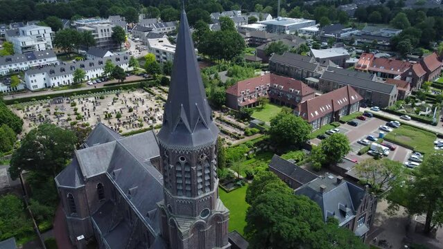 Rising aerial shot of a historic church and graveyard in a small town in the Netherlands