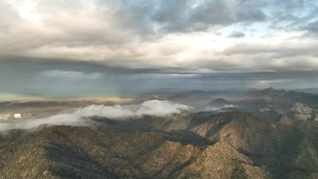 drone flies over mountains with moving clouds and haze full height 4k