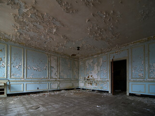 Chipping paint on walls and ceiling in an abandoned room