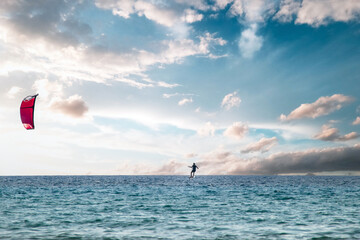 Naklejka premium Kitesurfer floats above the water in the open sea, panorama photo
