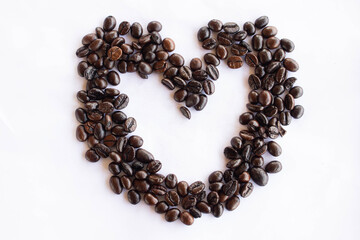 Coffee beans in the shape of a heart on a white background