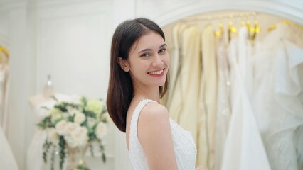 Fototapeta premium Smiling face of happy beautiful bride in white dress looking at camera at wedding studio