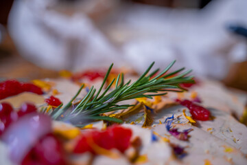 branche de romarin sur un plat de foie gras décoré de pétales de fleurs