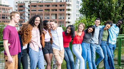 Happy group of multiracial young friends, diverse people smiling at camera outside, international community and joyful people