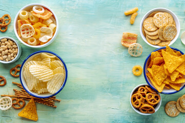 Salty snacks, overhead flat lay background with copy space. Party food frame. Potato and tortilla...