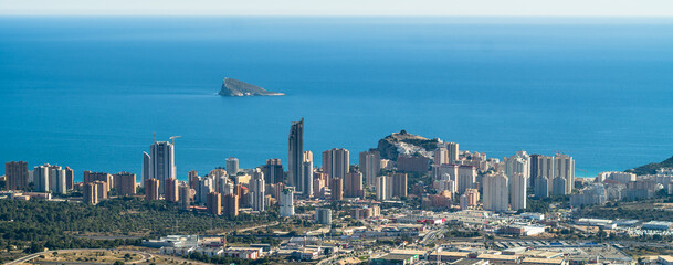 skyscrapers, apartment buildings and hotels with the sea in the background. Dense buildings of the city of Benidorm, seen from above. Blue sky, horizontal