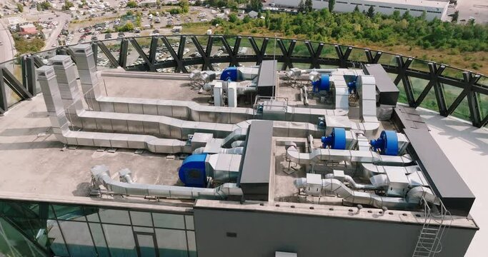 Ventilation systems on roof of large business center building in Sofia capital of Bulgaria aerial view drone turn summer sunny day. 