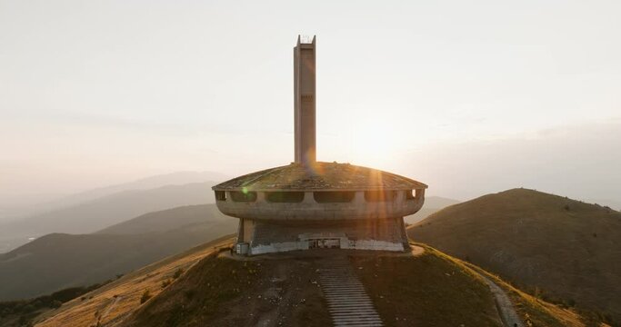 Buzludzha Memorial House in Bulgaria. Monument symbol to Communism on top of mountain sunset summer drone flyby areal view. Kazanlak Monument House Bulgarian Communist Party