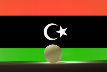 The table tennis ball stands on a surface in front of Libya flag.