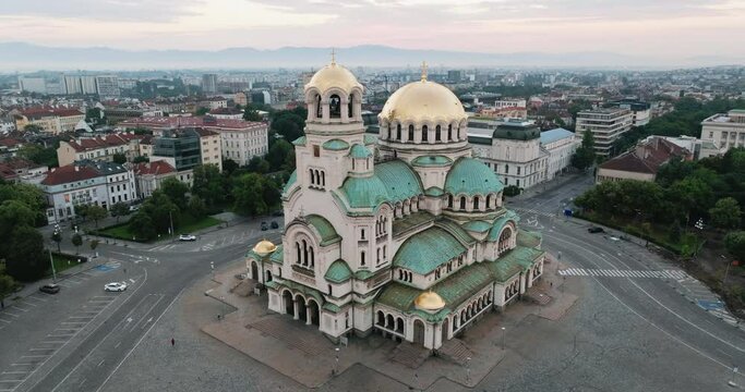 Orthodox Cathedral Alexander Nevsky in Sofia, Bulgaria in center of capital in summer at sunrise aerial view. Flying from drone. Green copper roof domes of cathedral. Neo-Byzantine style