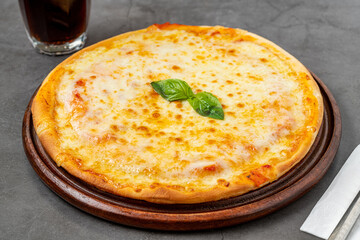 Italian pizza with four cheeses and lots of mozzarella on a cutting board