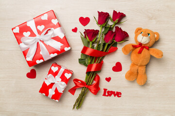 Valentines day gifts with red roses on wooden background, top view