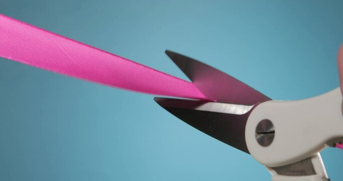 Cutting a pink ribbon