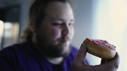 One fat man eating donut. Overweight person taking a bite of junk food. Sugar carb snack