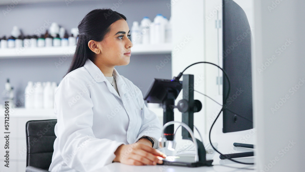 Poster Young scientist using a computer and microscope in a lab. Female pathologist analyzing medical samples while doing experiments to develop a cure. Microbiologist conducting forensic research
