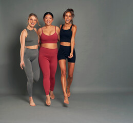 Full length of three young women in sports clothes in studio shot